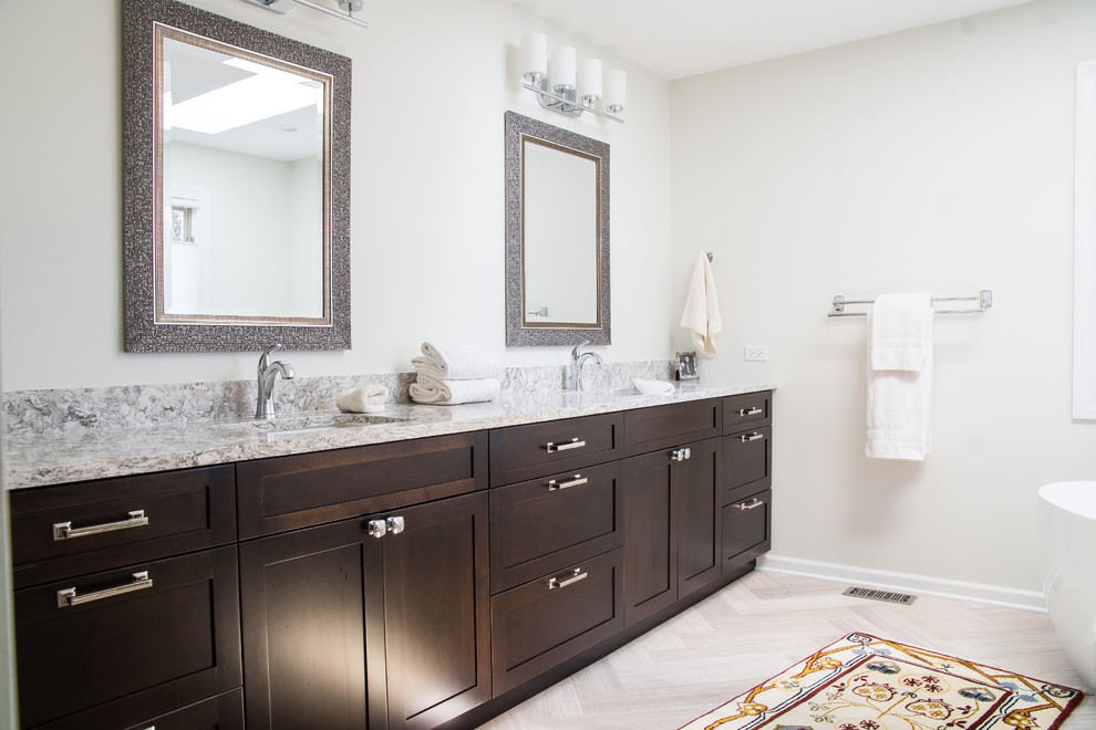 Large transitional master beige tile and limestone tile limestone floor and beige floor bathroom photo in Chicago with shaker cabinets, dark wood cabinets, a two-piece toilet, beige walls, an undermount sink, quartz countertops, a hinged shower door and beige countertops