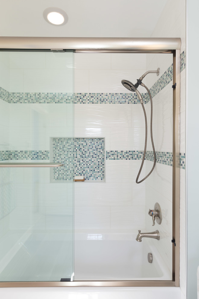 Exempel på ett mellanstort modernt en-suite badrum, med släta luckor, vita skåp, en dusch/badkar-kombination, en toalettstol med hel cisternkåpa, flerfärgad kakel, keramikplattor, mellanmörkt trägolv, ett undermonterad handfat, bänkskiva i kalksten, ett badkar i en alkov och gröna väggar