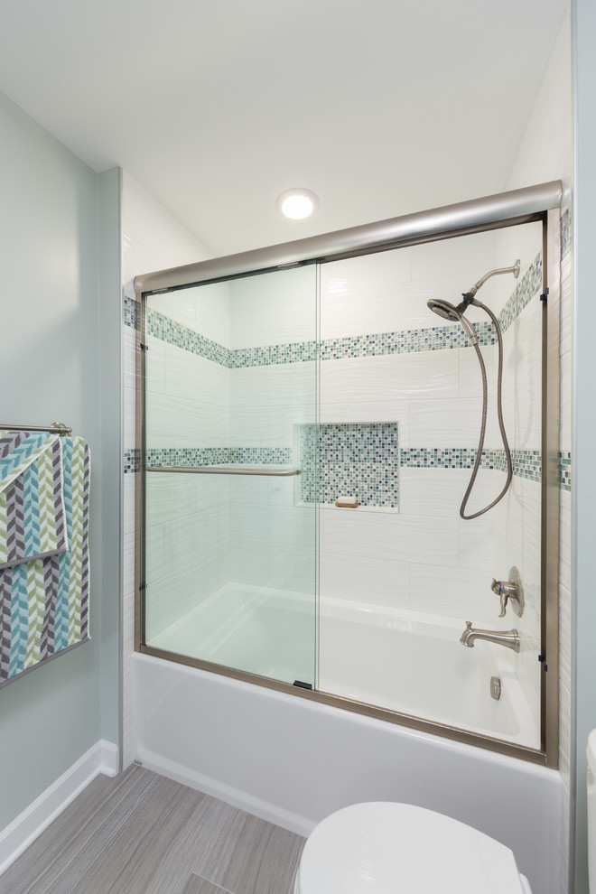 На фото: главная ванная комната среднего размера в современном стиле с плоскими фасадами, белыми фасадами, душем над ванной, унитазом-моноблоком, разноцветной плиткой, керамической плиткой, паркетным полом среднего тона, врезной раковиной, столешницей из известняка, ванной в нише и зелеными стенами