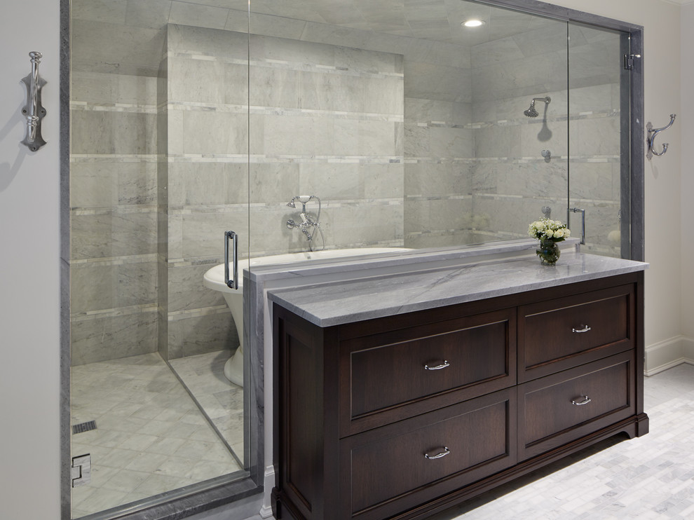 Diseño de cuarto de baño principal clásico renovado con puertas de armario de madera en tonos medios, bañera exenta, baldosas y/o azulejos de piedra, suelo de mármol y encimera de mármol