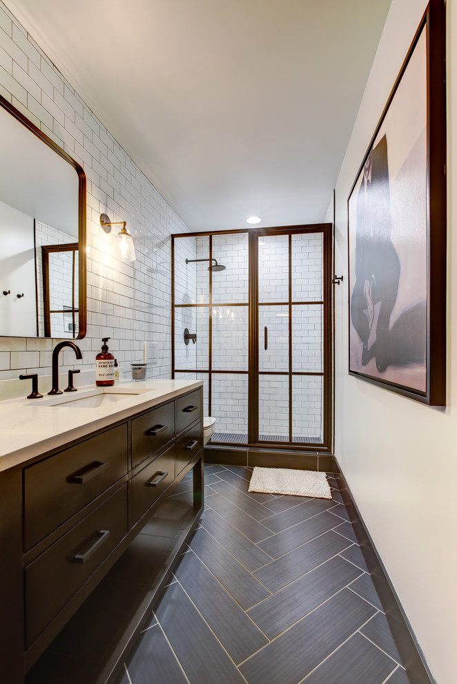 Design ideas for a medium sized industrial bathroom in Raleigh with black cabinets, a wall mounted toilet, white tiles, metro tiles, white walls, porcelain flooring, a submerged sink, engineered stone worktops, brown floors, a hinged door, an alcove shower and flat-panel cabinets.