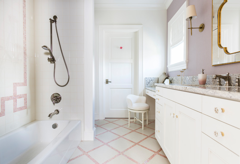 Idée de décoration pour une salle de bain tradition avec des portes de placard bleues et un plan de toilette en marbre.
