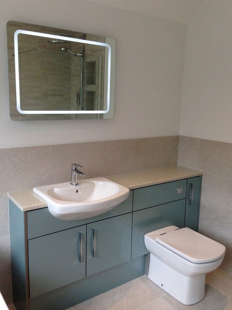Photo of a medium sized contemporary family bathroom in Berkshire with flat-panel cabinets, laminate worktops, a walk-in shower, a one-piece toilet, grey tiles, porcelain tiles, grey walls and porcelain flooring.