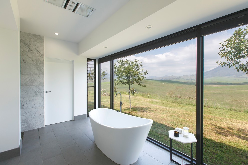 Ispirazione per una stanza da bagno contemporanea di medie dimensioni con vasca freestanding, pavimento con piastrelle in ceramica e pavimento grigio