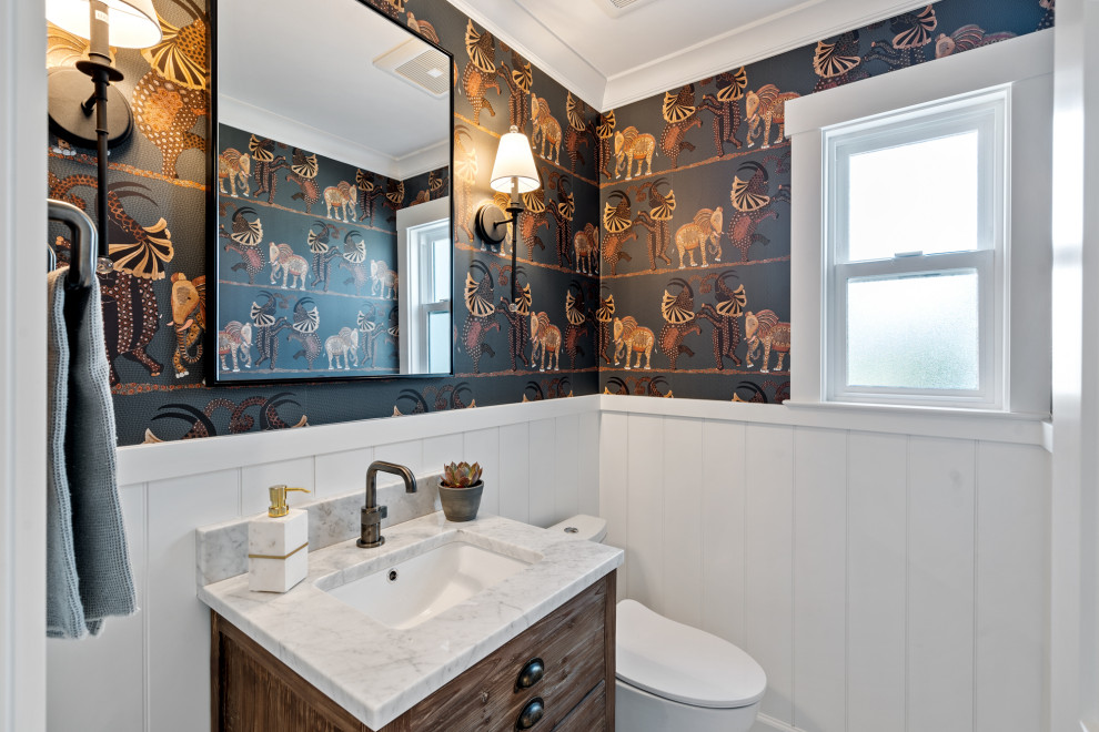 Transitional single-sink, wainscoting and wallpaper bathroom photo in San Francisco with flat-panel cabinets, medium tone wood cabinets, multicolored walls, an undermount sink, white countertops and a freestanding vanity