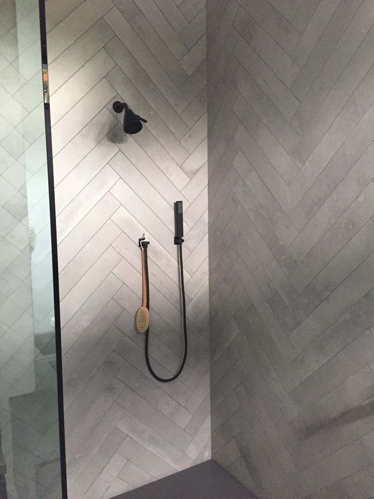 Design ideas for a large modern shower room bathroom in Los Angeles with flat-panel cabinets, a corner shower, a two-piece toilet, ceramic tiles, white walls, cement flooring, an integrated sink, grey floors, a hinged door, black cabinets, beige tiles and solid surface worktops.