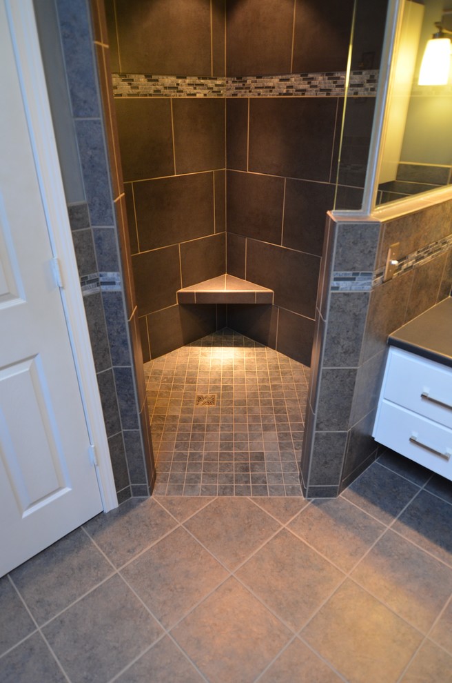 Example of a mid-sized classic master gray tile and porcelain tile porcelain tile and brown floor bathroom design in Denver with raised-panel cabinets, dark wood cabinets, beige walls, a wall-mount sink and granite countertops