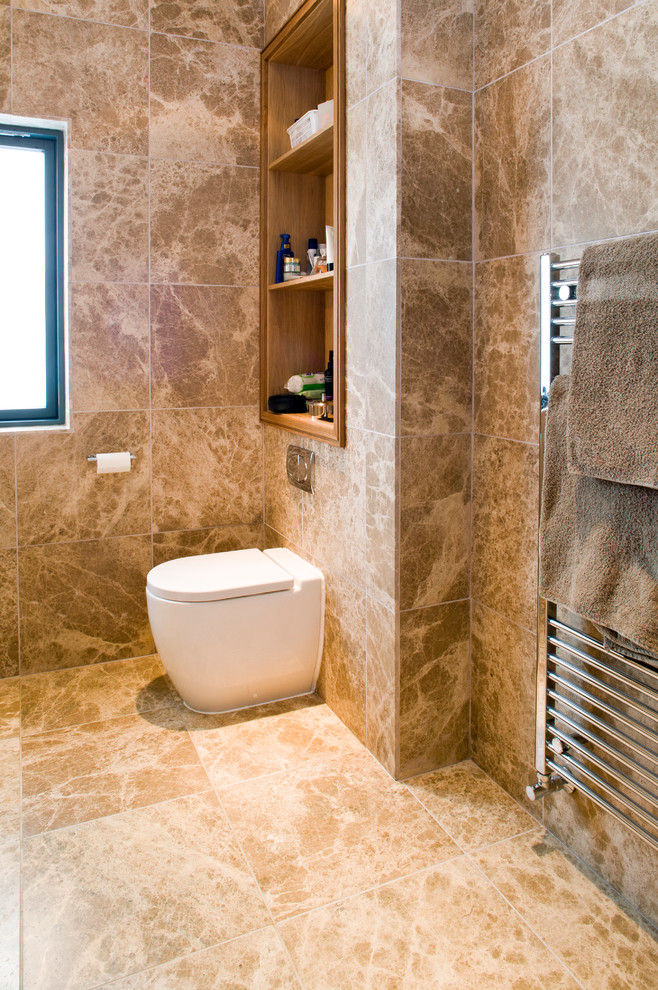 Inspiration för mellanstora moderna en-suite badrum, med öppna hyllor, skåp i ljust trä, en toalettstol med hel cisternkåpa, brun kakel, stenkakel, bruna väggar och marmorgolv