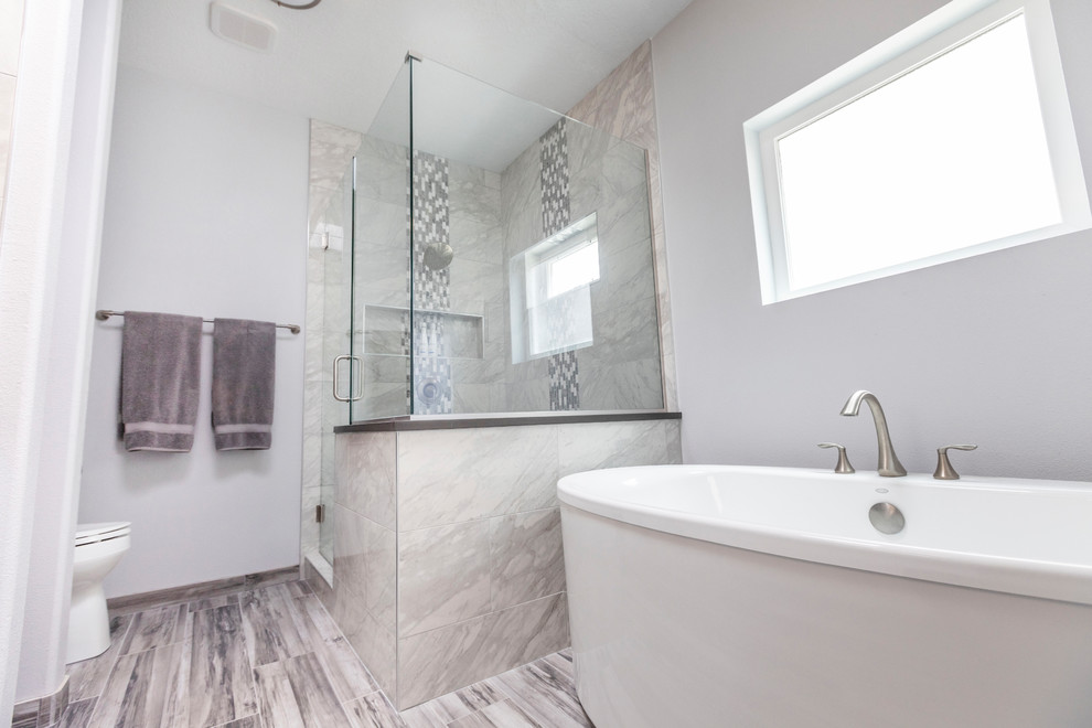 Bathroom - mid-sized modern master white tile and marble tile porcelain tile and gray floor bathroom idea in Albuquerque with flat-panel cabinets, white cabinets, a one-piece toilet, white walls, an undermount sink, quartz countertops, a hinged shower door and gray countertops