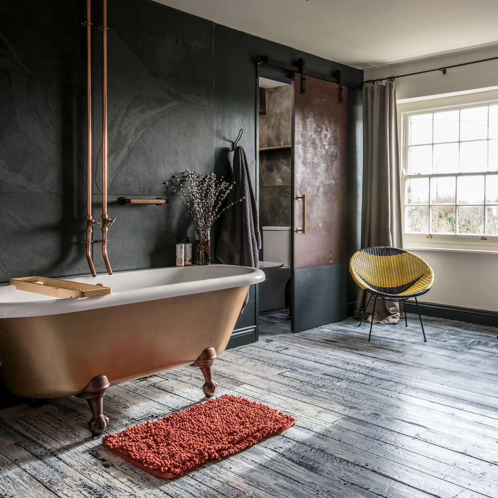 Inspiration for a contemporary ensuite bathroom in Other with a claw-foot bath, black tiles, black walls, painted wood flooring and copper worktops.