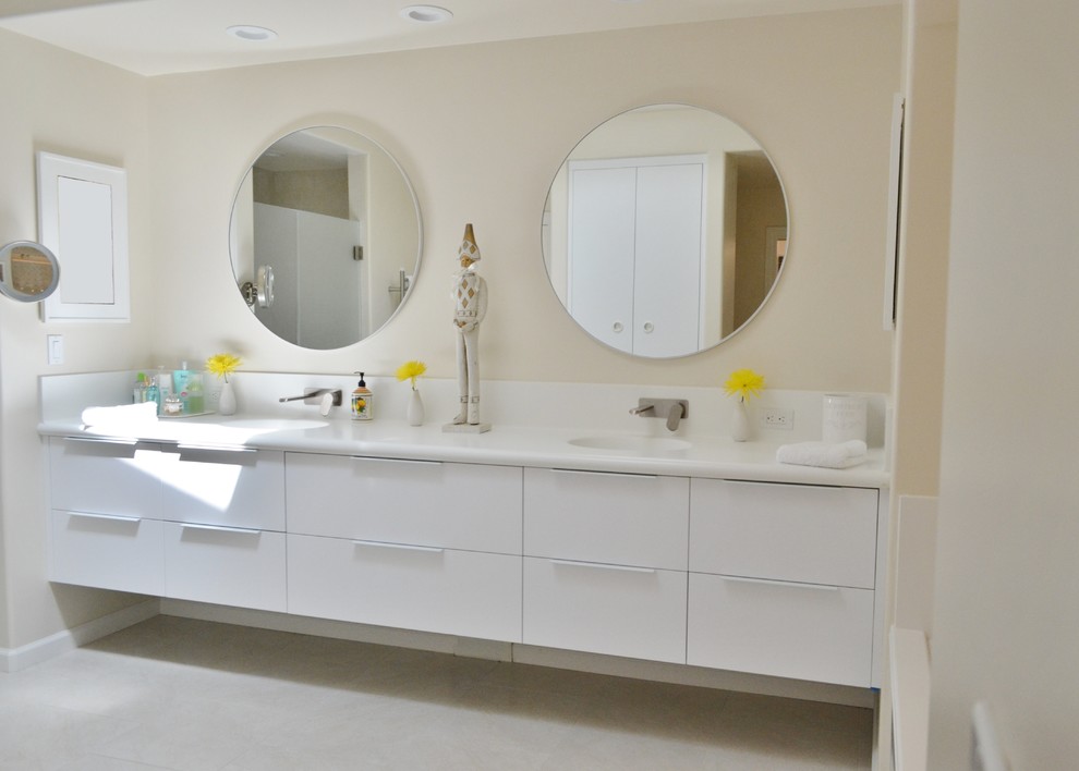 На фото: огромная главная ванная комната в стиле модернизм с плоскими фасадами, белыми фасадами, накладной ванной, душем без бортиков, унитазом-моноблоком, белой плиткой, керамической плиткой, белыми стенами, полом из керамогранита, монолитной раковиной, столешницей из искусственного камня, белым полом и душем с распашными дверями с
