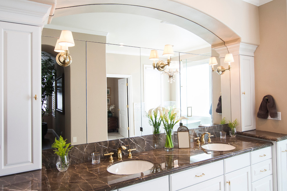 Inredning av ett klassiskt stort en-suite badrum, med luckor med glaspanel, vita skåp, ett fristående badkar, en dubbeldusch, en bidé, vit kakel, porslinskakel, beige väggar, mosaikgolv, ett undermonterad handfat och marmorbänkskiva