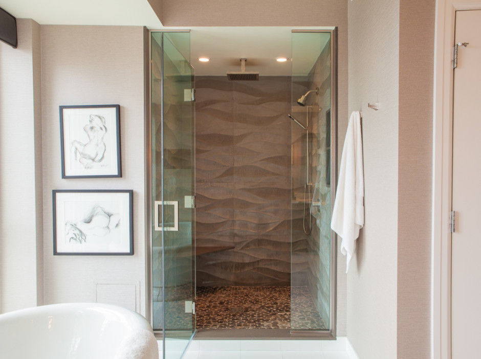 Cette image montre une douche en alcôve principale traditionnelle de taille moyenne avec une baignoire indépendante, un carrelage marron, une plaque de galets et un mur beige.