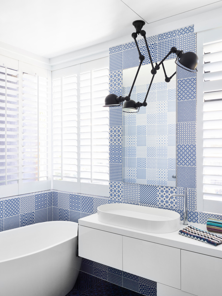 ブリスベンにあるコンテンポラリースタイルのおしゃれな浴室 (フラットパネル扉のキャビネット、白いキャビネット、置き型浴槽、青いタイル、ベッセル式洗面器、白い洗面カウンター、洗面台1つ、フローティング洗面台) の写真