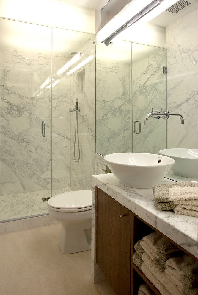 Example of a small minimalist 3/4 beige tile limestone floor bathroom design in Chicago with flat-panel cabinets, medium tone wood cabinets, a one-piece toilet, marble countertops and a vessel sink