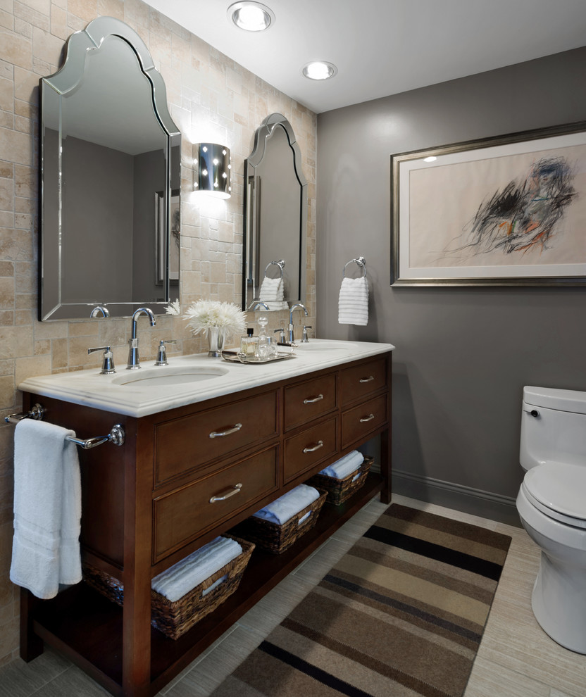 Exemple d'une salle de bain chic en bois foncé avec un lavabo encastré, un carrelage beige et un placard à porte affleurante.