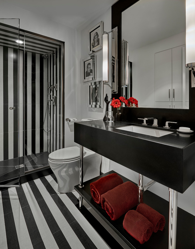 На фото: ванная комната среднего размера в современном стиле с открытыми фасадами, душем в нише, унитазом-моноблоком, черной плиткой, черно-белой плиткой, белой плиткой, белыми стенами, душевой кабиной, врезной раковиной, разноцветным полом, душем с распашными дверями и черной столешницей с