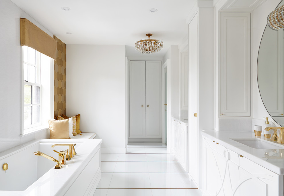 Foto de cuarto de baño principal tradicional renovado de tamaño medio con paredes blancas, puertas de armario blancas, bañera encastrada sin remate, lavabo bajoencimera y suelo blanco