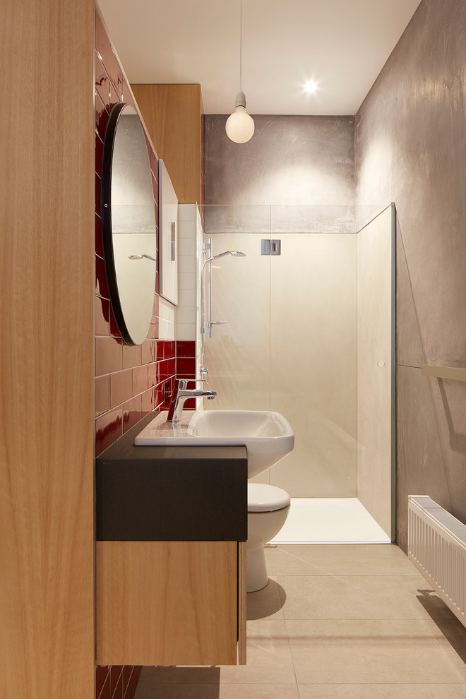 Idées déco pour une petite douche en alcôve principale contemporaine en bois brun avec un placard à porte plane, une baignoire indépendante, WC suspendus, un carrelage rouge, des carreaux de céramique, un mur gris, un sol en carrelage de céramique et un lavabo posé.