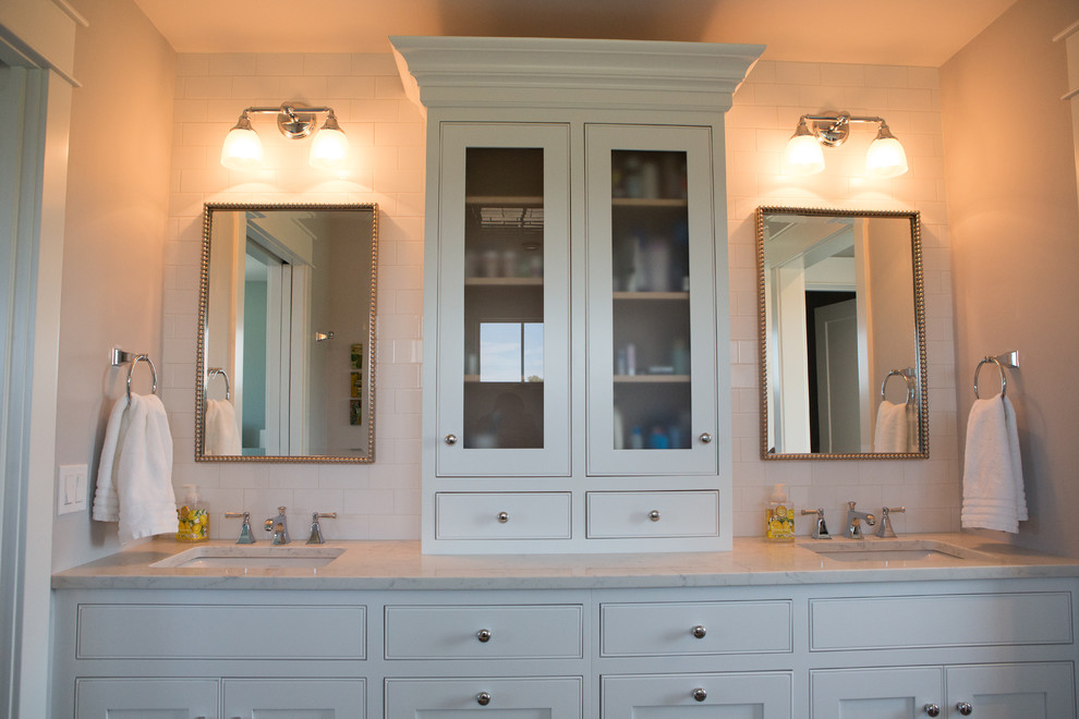 Klassisk inredning av ett stort en-suite badrum, med skåp i shakerstil, vita skåp, en dubbeldusch, en toalettstol med separat cisternkåpa, vit kakel, keramikplattor, vita väggar, klinkergolv i porslin, ett undermonterad handfat, bänkskiva i kvarts, grått golv och dusch med gångjärnsdörr
