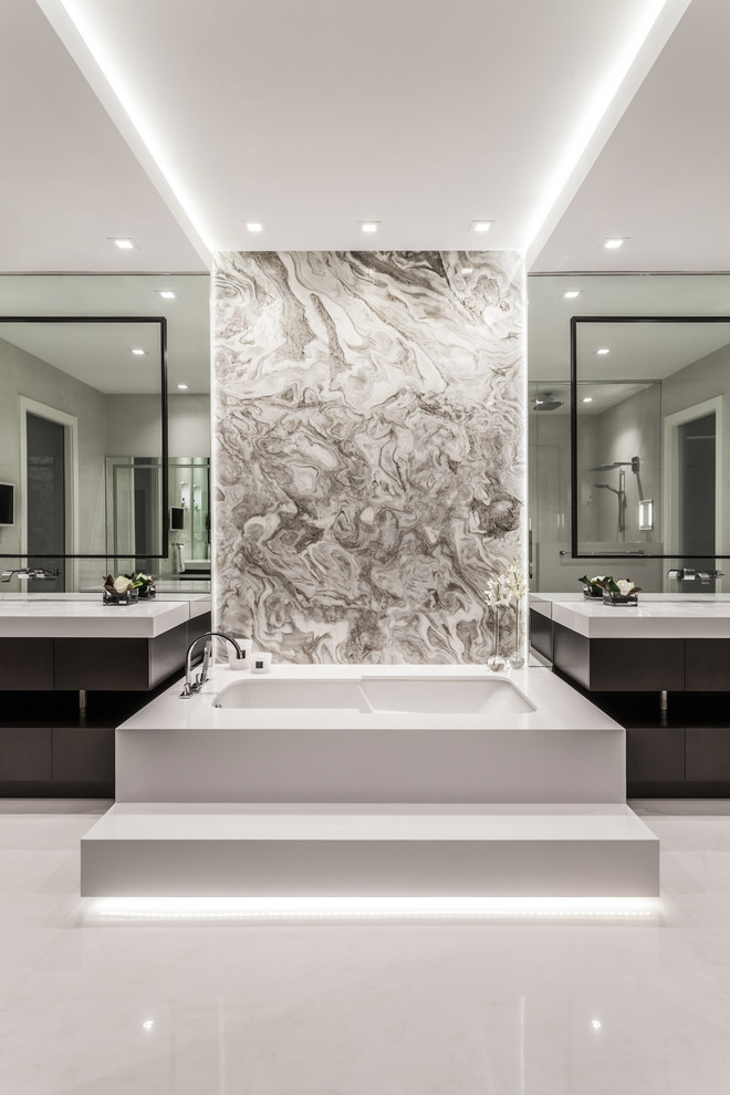 Example of a large trendy master concrete floor and white floor bathroom design in Miami with flat-panel cabinets, dark wood cabinets, an undermount tub, an integrated sink and white countertops