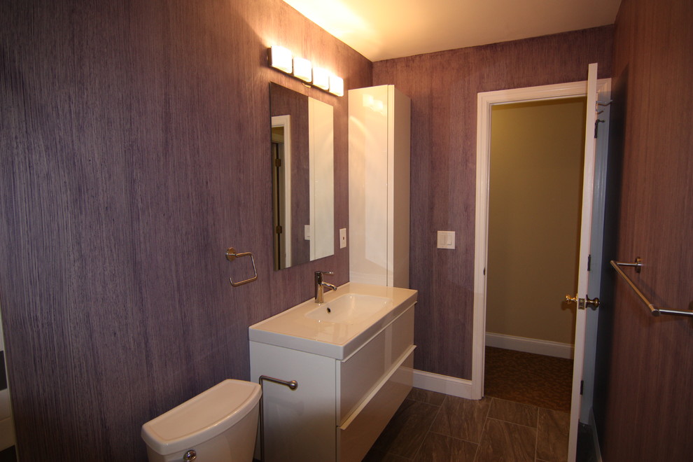 Bild på ett mellanstort funkis badrum för barn, med ett väggmonterat handfat, släta luckor, vita skåp, ett badkar i en alkov, en dusch/badkar-kombination, en toalettstol med separat cisternkåpa, flerfärgad kakel, porslinskakel, lila väggar och klinkergolv i porslin