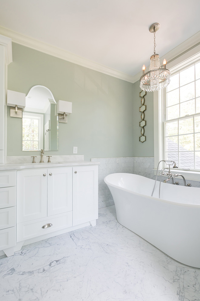 Inspiration for a mid-sized transitional master white tile and marble tile marble floor and white floor bathroom remodel in Charleston with shaker cabinets, white cabinets, a one-piece toilet, gray walls, an undermount sink, marble countertops and a hinged shower door