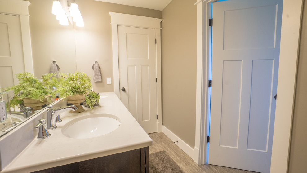 Foto på ett mellanstort amerikanskt en-suite badrum, med bruna skåp, beige väggar, ett integrerad handfat och marmorbänkskiva