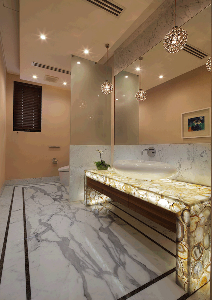 Idées déco pour une salle de bain contemporaine en bois foncé avec une vasque et un placard à porte plane.