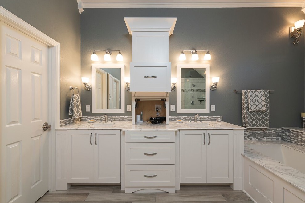 Inspiration for a large transitional master gray tile and marble tile light wood floor and brown floor walk-in shower remodel in Dallas with shaker cabinets, white cabinets, an undermount tub, gray walls, an undermount sink, marble countertops and a hinged shower door