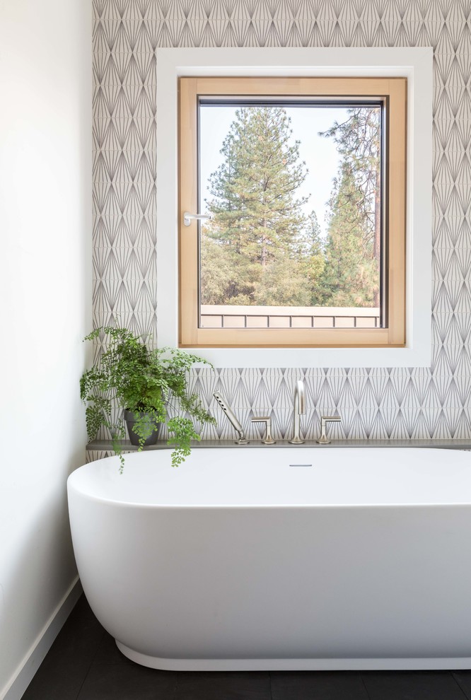 Modernes Badezimmer mit freistehender Badewanne, grauen Fliesen, weißer Wandfarbe und schwarzem Boden in Sacramento