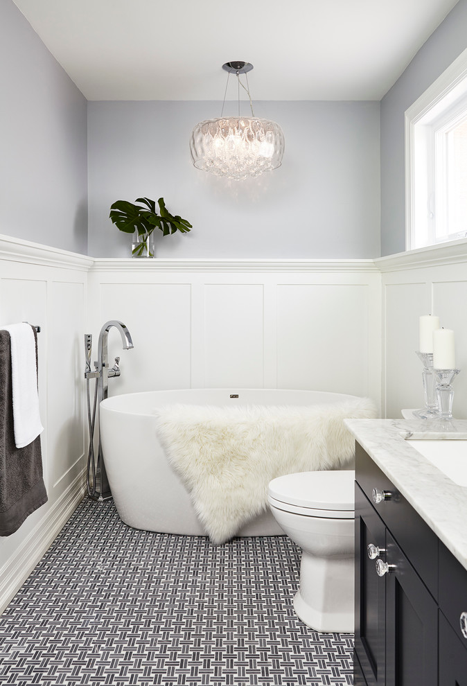 Inspiration för ett mellanstort vintage badrum, med luckor med infälld panel, skåp i mörkt trä, ett fristående badkar, lila väggar, klinkergolv i porslin, ett undermonterad handfat och marmorbänkskiva