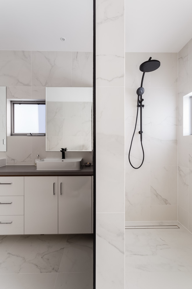 Idéer för att renovera ett funkis grå grått en-suite badrum, med släta luckor, vita skåp, en dusch i en alkov, vit kakel, marmorkakel, vita väggar, marmorgolv, ett fristående handfat, vitt golv, med dusch som är öppen och bänkskiva i akrylsten