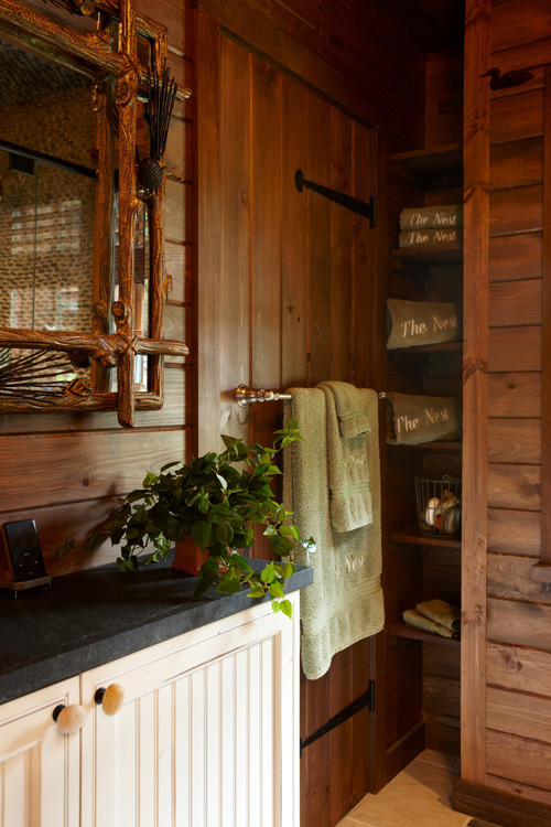 Exemple d'une salle de bain montagne en bois vieilli avec un lavabo encastré, un plan de toilette en stéatite, une douche à l'italienne, WC séparés, un carrelage noir, une plaque de galets et un sol en carrelage de porcelaine.