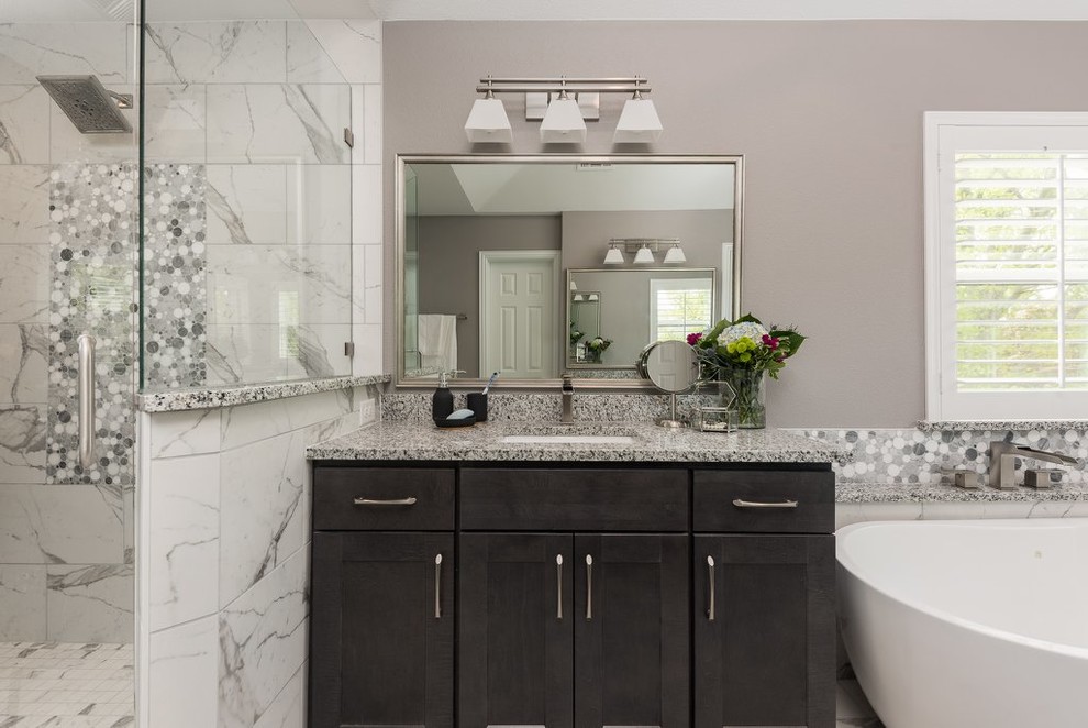 Bathroom - large transitional master multicolored tile and marble tile marble floor and multicolored floor bathroom idea in Dallas with shaker cabinets, dark wood cabinets, a one-piece toilet, gray walls, an undermount sink, granite countertops, a hinged shower door and multicolored countertops