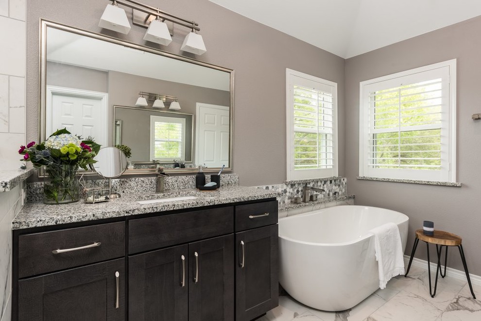 Inspiration for a large transitional master multicolored tile and marble tile marble floor and multicolored floor bathroom remodel in Dallas with shaker cabinets, dark wood cabinets, a one-piece toilet, gray walls, an undermount sink, granite countertops, a hinged shower door and multicolored countertops