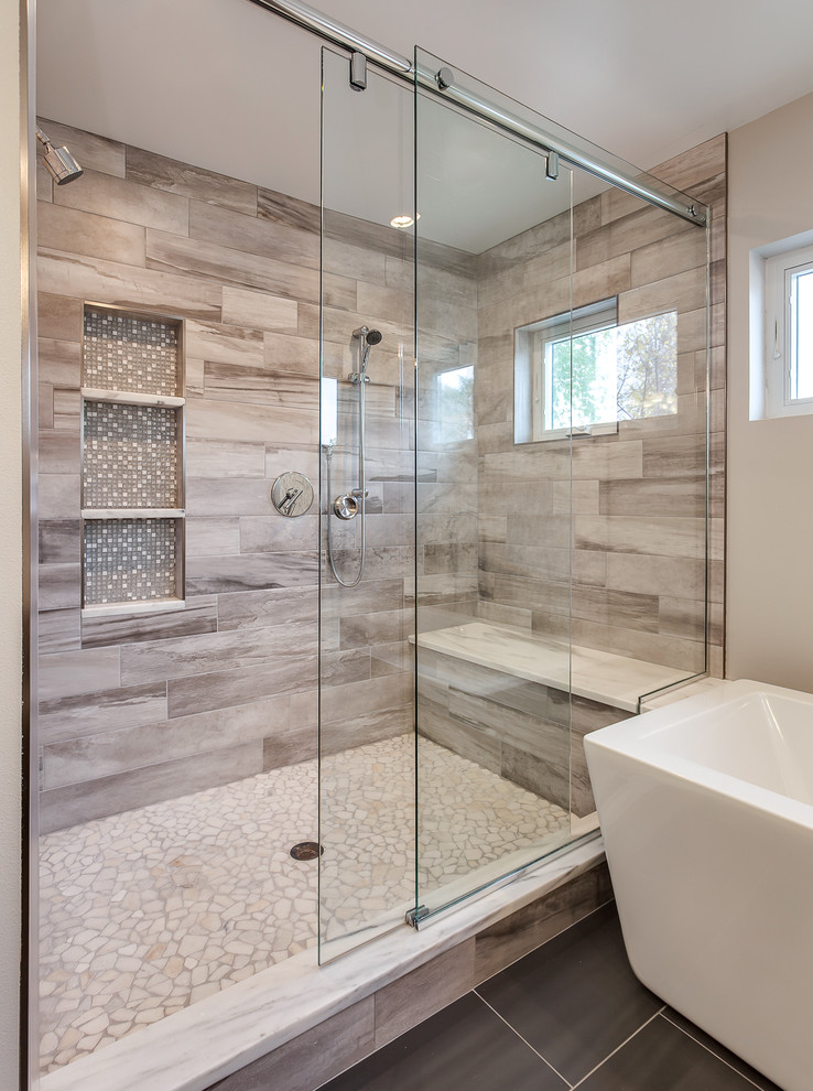 Réalisation d'une très grande salle de bain principale design avec une baignoire indépendante, une douche ouverte, un carrelage beige, des carreaux de céramique, un mur gris, un lavabo encastré et un plan de toilette en granite.