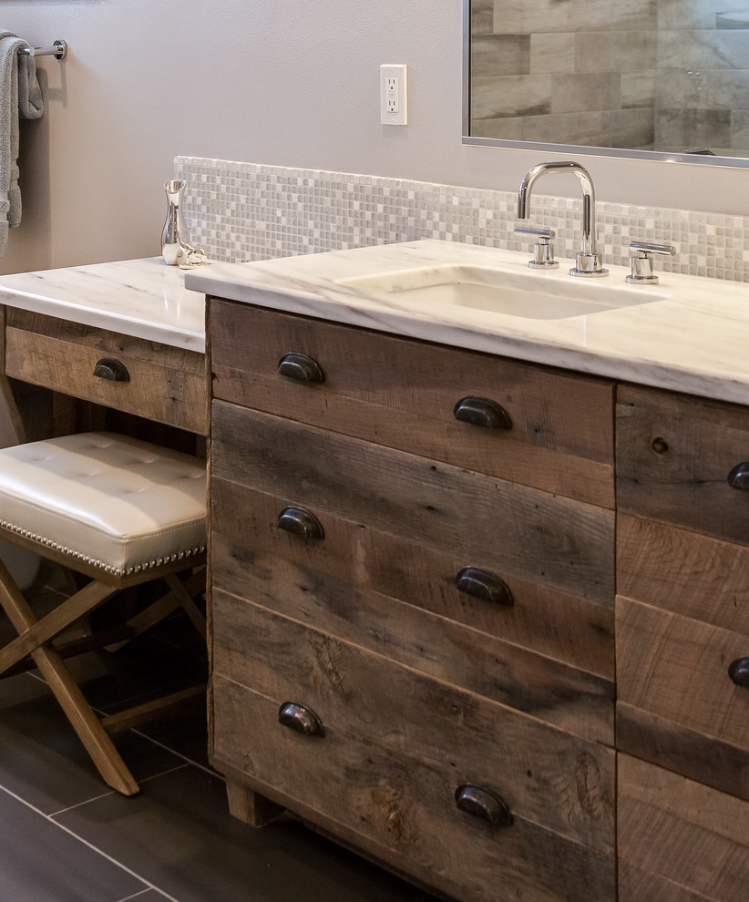 Inspiration for an expansive contemporary ensuite bathroom in Denver with flat-panel cabinets, distressed cabinets, a freestanding bath, a walk-in shower, beige tiles, ceramic tiles, grey walls, medium hardwood flooring, a submerged sink and granite worktops.