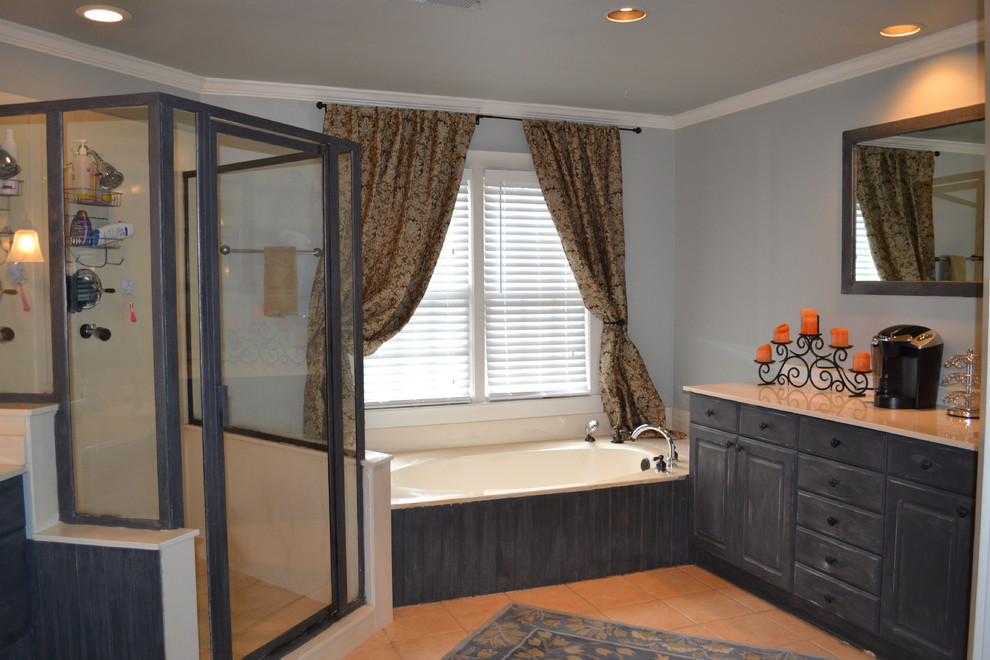 Bild på ett amerikanskt en-suite badrum, med luckor med upphöjd panel, skåp i slitet trä, granitbänkskiva, ett platsbyggt badkar, en hörndusch, beige kakel, stenkakel, blå väggar och travertin golv