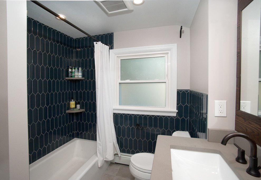 Inspiration pour une salle de bain principale rustique de taille moyenne avec un placard à porte plane, des portes de placard blanches, une baignoire d'angle, une douche d'angle, WC à poser, un carrelage bleu, des carreaux de céramique, un mur blanc, un sol en carrelage de céramique, un lavabo encastré, une cabine de douche avec un rideau, un plan de toilette en surface solide, un sol gris et un plan de toilette gris.