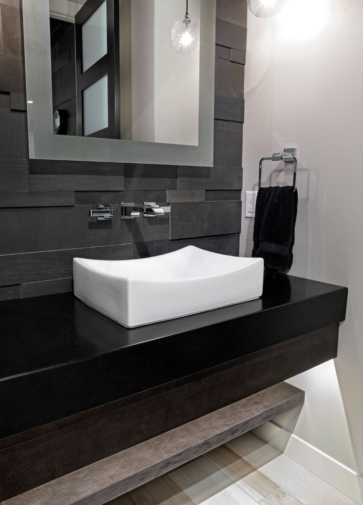 Immagine di una stanza da bagno con doccia minimalista di medie dimensioni con ante marroni, piastrelle grigie, pareti grigie, lavabo a bacinella, top in superficie solida e top nero