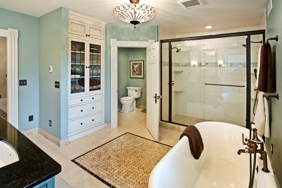 На фото: главная ванная комната в викторианском стиле с ванной на ножках, двойным душем, раздельным унитазом, белой плиткой, керамической плиткой, зелеными стенами, врезной раковиной, искусственно-состаренными фасадами, фасадами с декоративным кантом и мраморным полом с