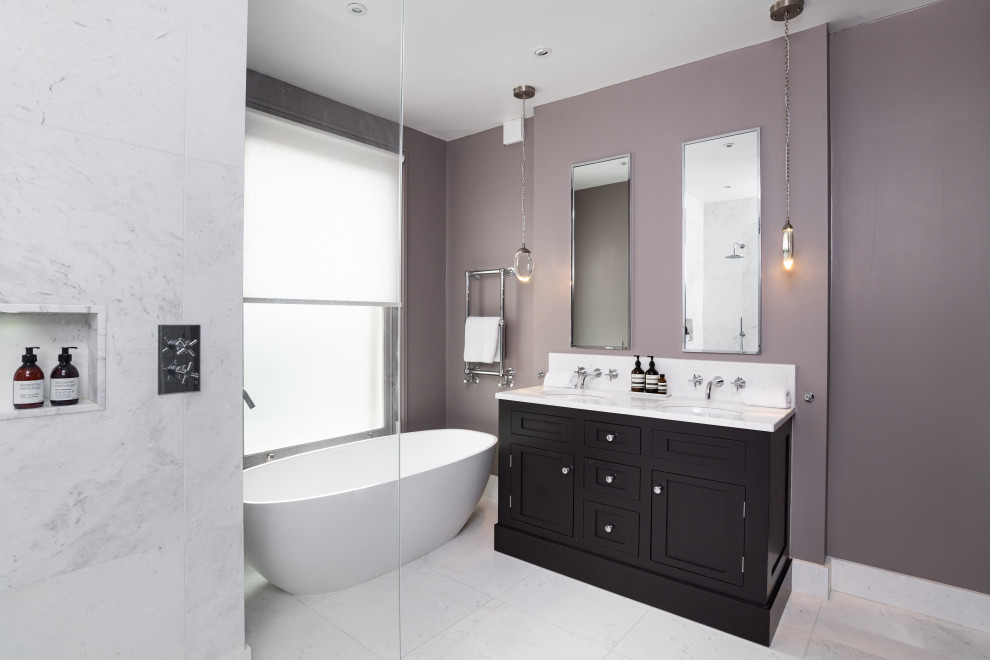 Immagine di una stanza da bagno tradizionale con ante in stile shaker, ante nere, vasca freestanding, pareti grigie, lavabo sottopiano, pavimento bianco e top bianco