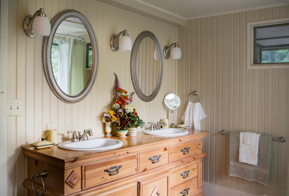 This is an example of a rural bathroom in St Louis with a built-in sink, beige walls, medium wood cabinets and raised-panel cabinets.