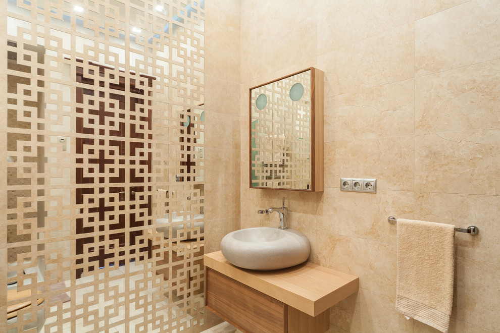 Idee per una stanza da bagno minimal con WC sospeso, piastrelle beige, piastrelle a specchio, pareti beige e lavabo a bacinella