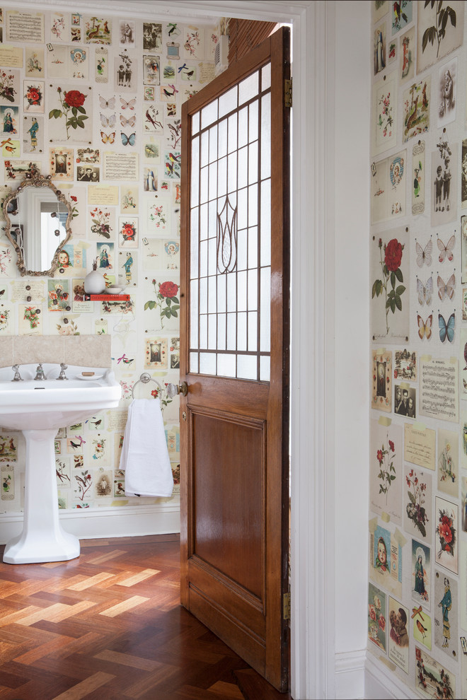 Aménagement d'une salle d'eau éclectique avec un carrelage beige, un mur multicolore, un sol en bois brun, un lavabo de ferme et un sol marron.