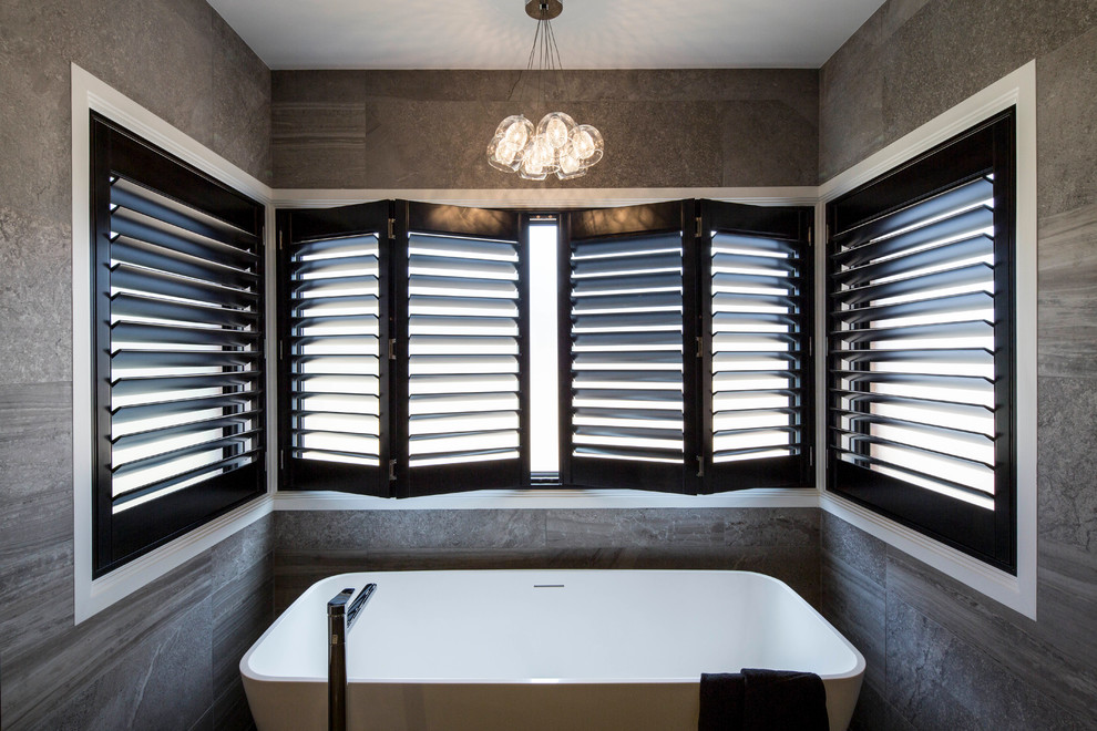 Modern inredning av ett en-suite badrum, med ett fristående badkar och flerfärgad kakel