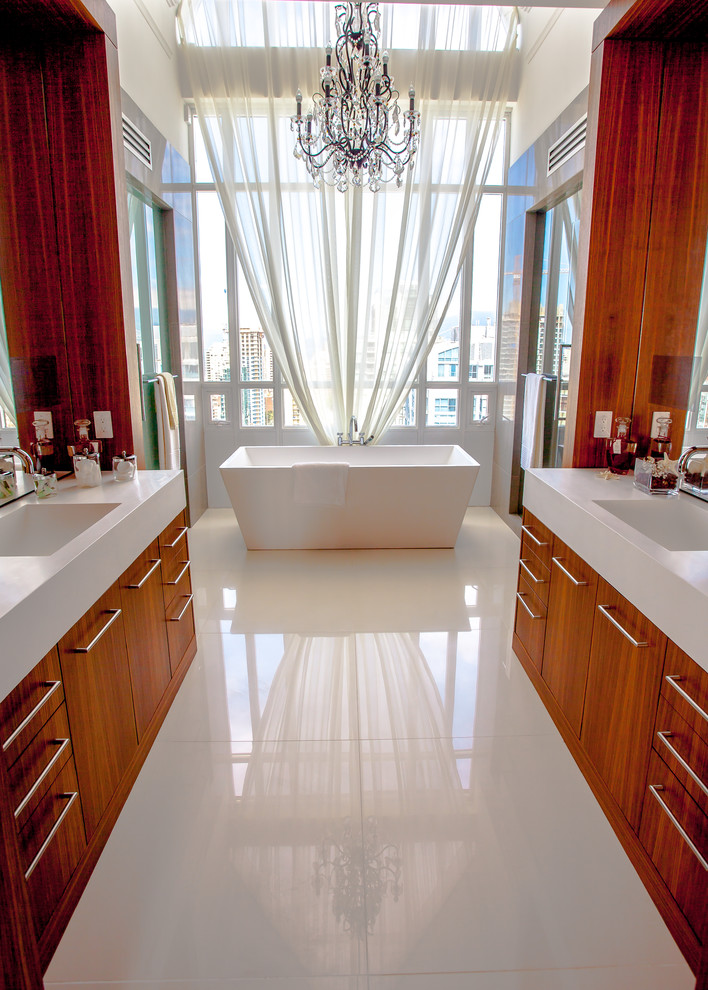 Foto di una stanza da bagno design con lavabo integrato, ante lisce, ante in legno scuro, vasca freestanding e piastrelle bianche