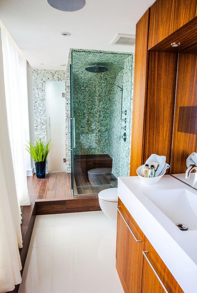Свежая идея для дизайна: ванная комната в современном стиле с монолитной раковиной, плоскими фасадами, фасадами цвета дерева среднего тона, душем в нише, синей плиткой и плиткой мозаикой - отличное фото интерьера