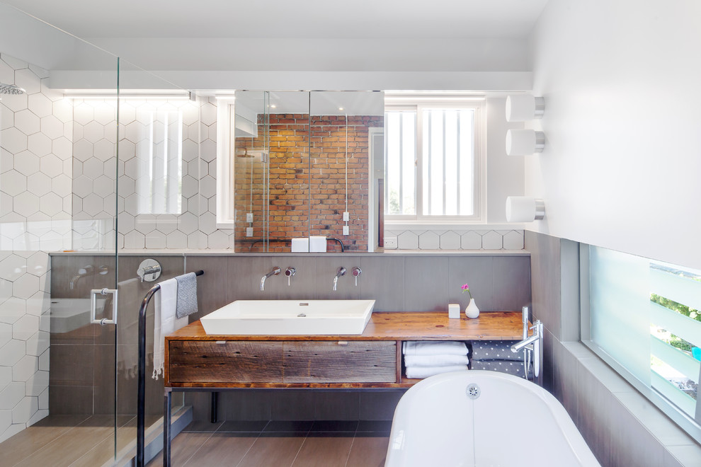 Свежая идея для дизайна: ванная комната в современном стиле с искусственно-состаренными фасадами, душем в нише, белой плиткой, белыми стенами, раковиной с несколькими смесителями, столешницей из дерева, душем с распашными дверями, окном и плоскими фасадами - отличное фото интерьера